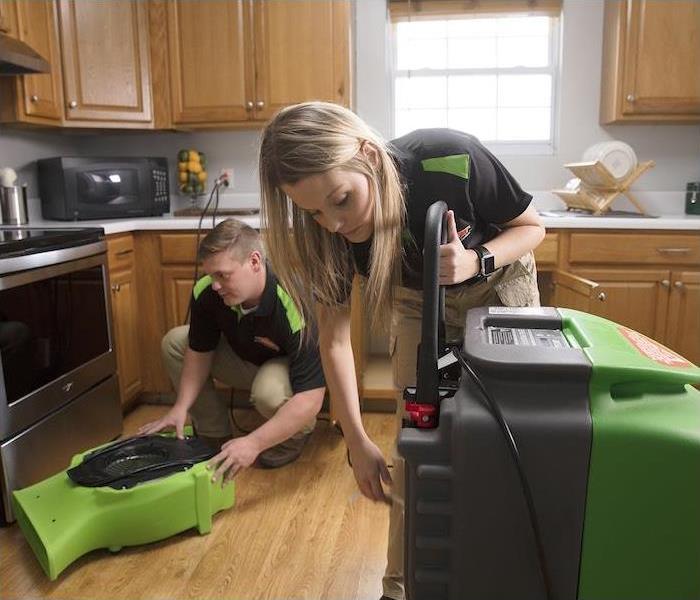  "a SERVPRO crew setting up machines to clean a kitchen 